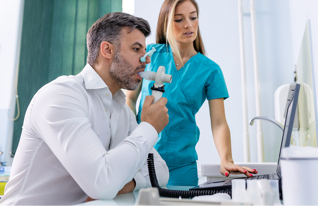 Niño usando inhalador con ayuda de profesional médico